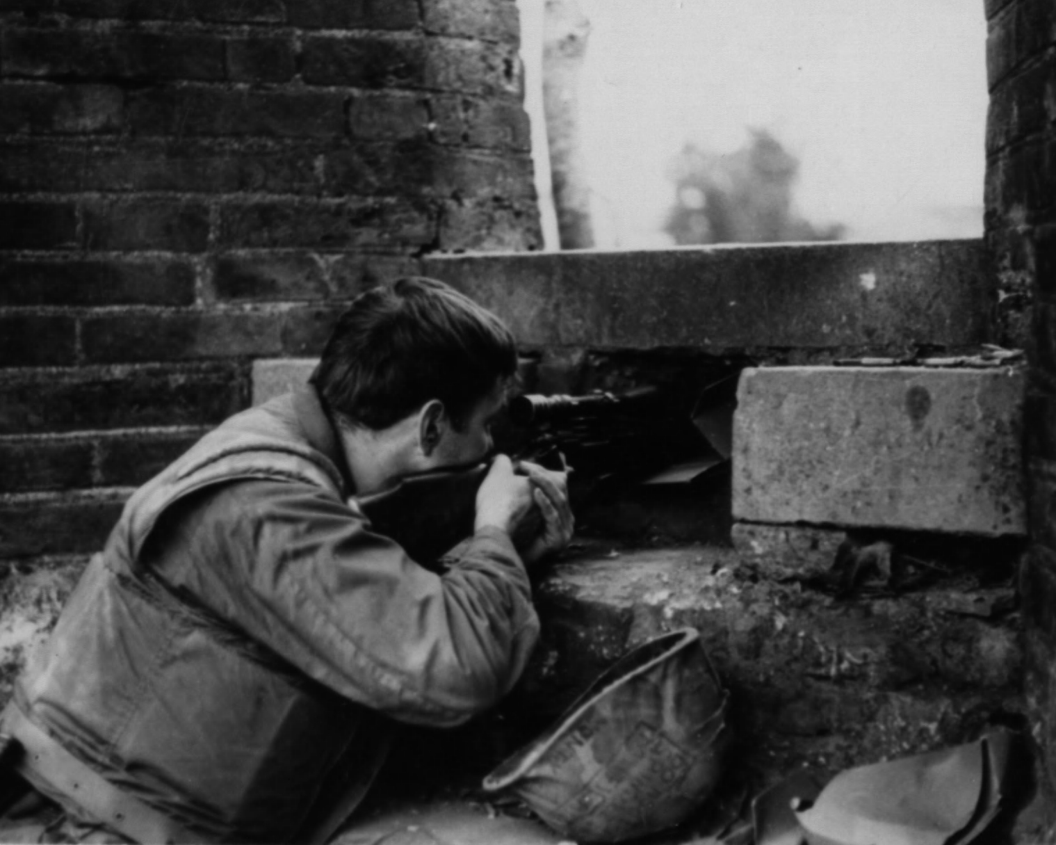 Marine sniper from D Company, 1st Battalion 5th Marines takes aim through a breach in a wall during the Battle of Hue, 22 February 1968