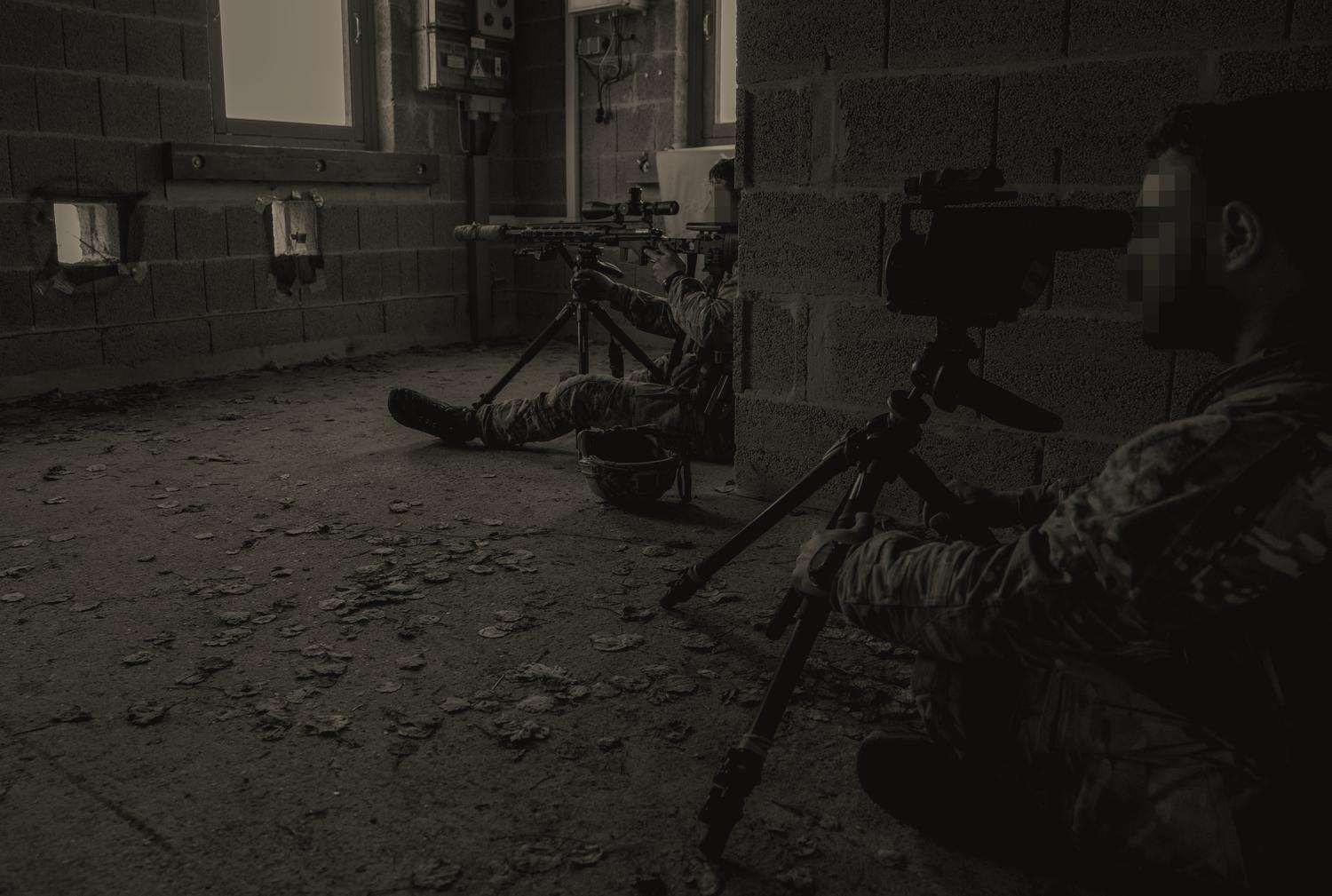 A sniper team in a breeze-block room on the International Special Training Center&rsquo;s urban sniper course: one man behind a rifle on a tripod at a loophole cut in the wall, another behind a spotting scope