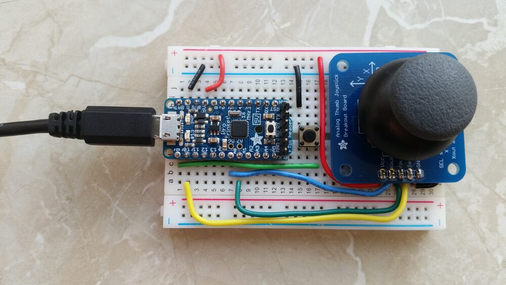A real breadboard build: a small microcontroller board and a joystick breakout wired together with jumper wires, powered from the rails.