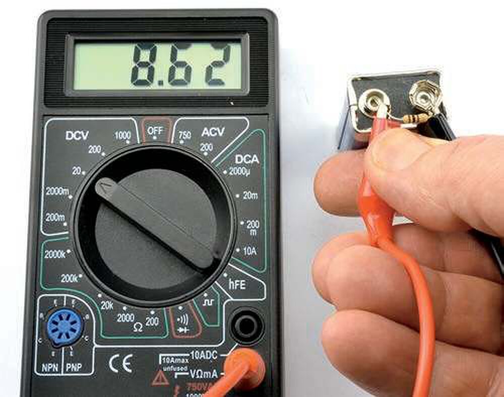 A multimeter reading 8.62 volts across a 9-volt battery with a resistor across its terminals as a dummy load